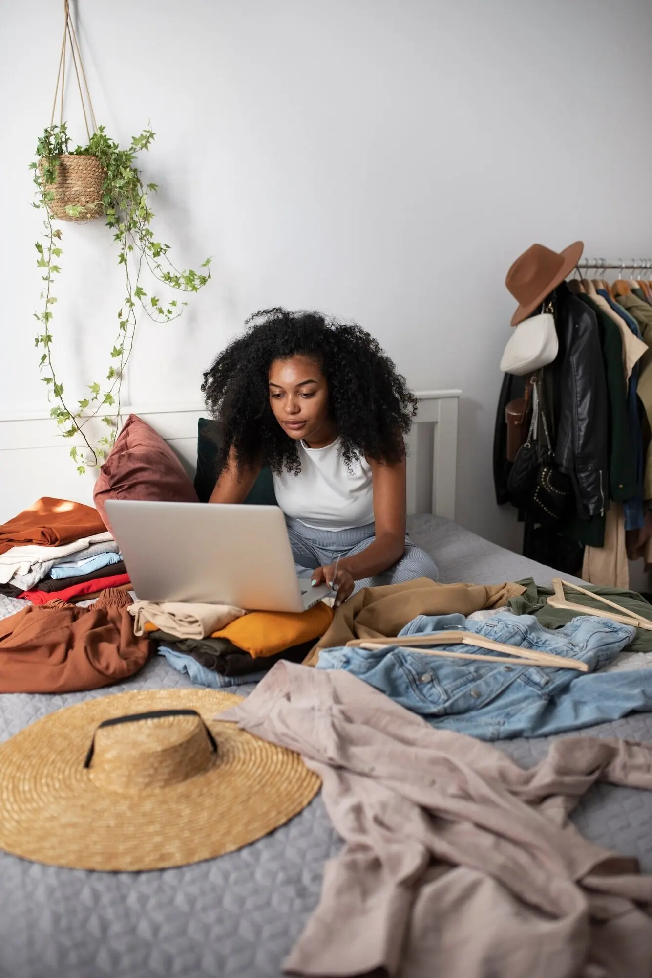 Ganzkörperaufnahme einer Frau im Bett mit einem Laptop.